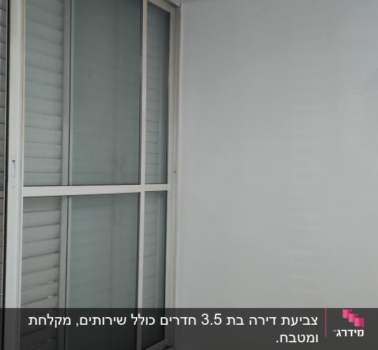 קיר צבוע בלבן ליד חלון עם תריסים